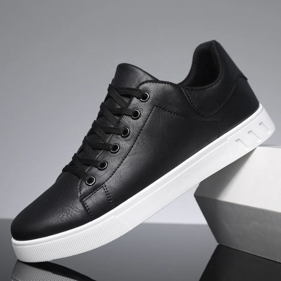Black sneaker with white sole on a reflective surface