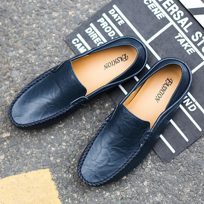 Pair of navy loafers on a gray surface with a black and white background