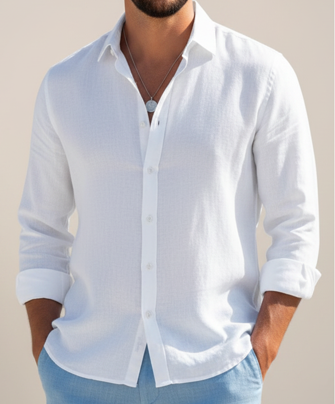 Man wearing a white button-up shirt with rolled-up sleeves against a beige background