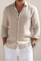 Man wearing a beige button-up shirt with a plain background