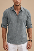 Man wearing a gray short-sleeve shirt with rolled-up sleeves on a beige background