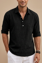 Man wearing a black short-sleeve shirt with rolled-up sleeves on a beige background
