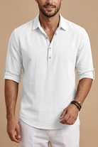 Man wearing a white short-sleeve shirt and pants against a beige background