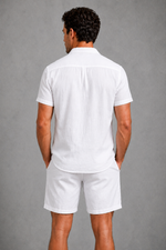Man wearing a white shirt and shorts against a gray background
