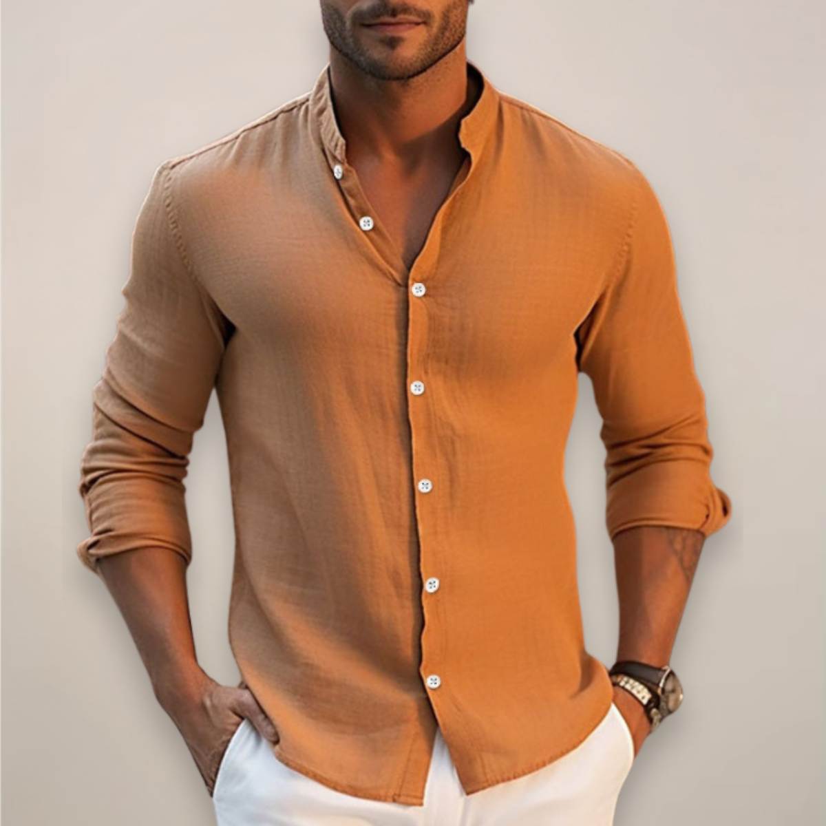 Man wearing a brown button-up shirt with rolled-up sleeves against a neutral background