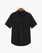 Black short-sleeve shirt on a hanger against a white background