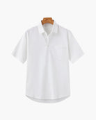 White shirt on a wooden hanger against a white background