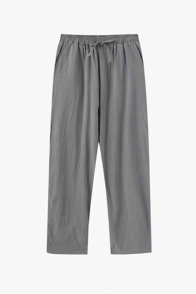 Gray pants on a wooden hanger against a white background