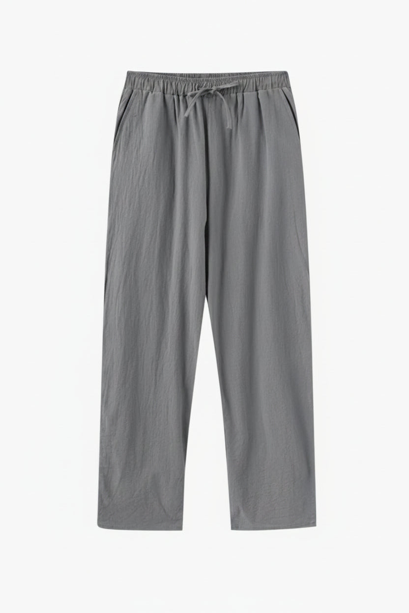 Gray pants on a wooden hanger against a white background