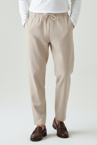 Beige pants worn by a person on a white background