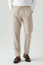 Beige pants worn by a person on a white background
