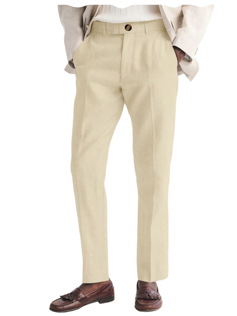 Beige dress pants worn with a white shirt and brown loafers on a white background
