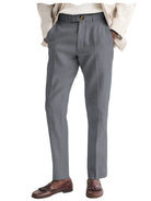 Gray dress pants worn with a beige blazer and brown shoes on a white background