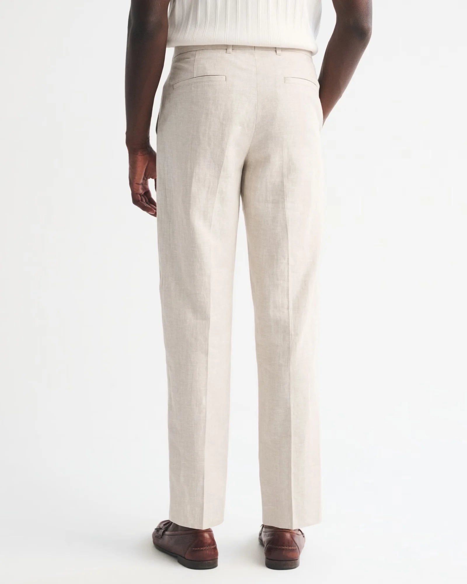 Person wearing beige dress pants on a white background