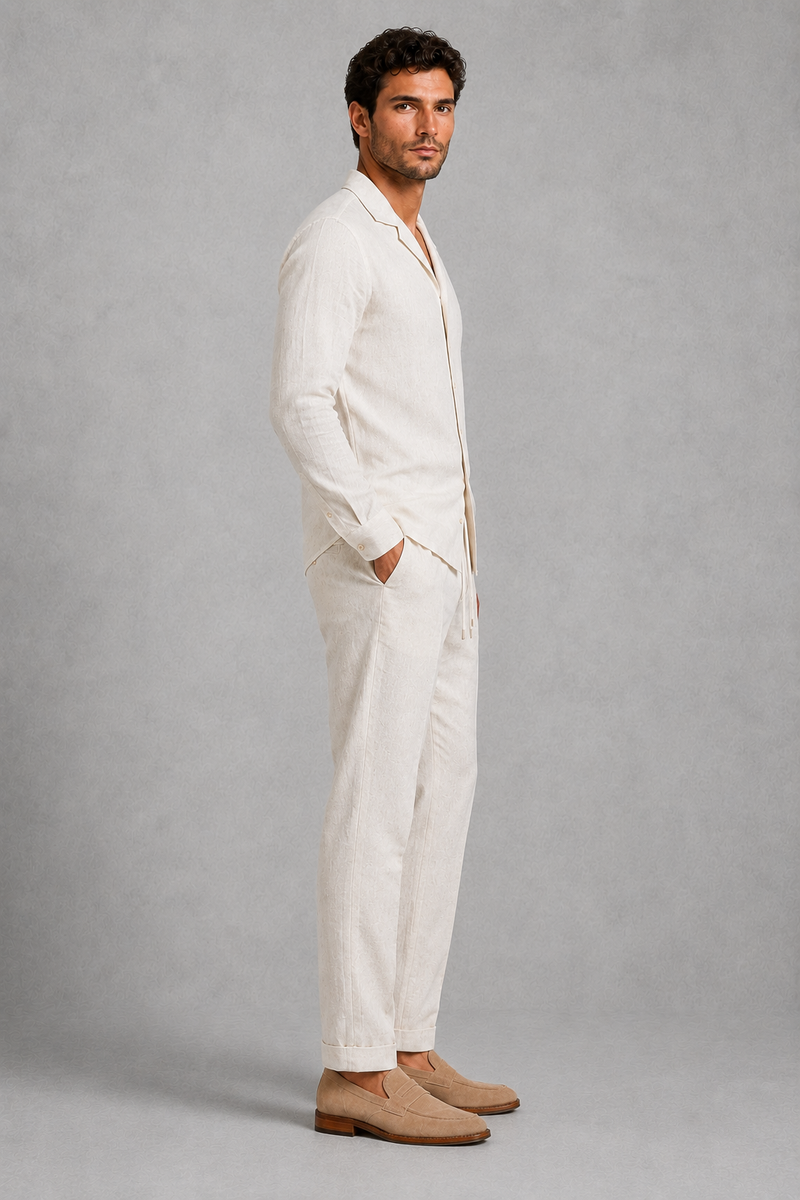 Man wearing a white linen suit with beige shoes on a gray background