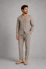 Man wearing a beige linen suit against a gray background