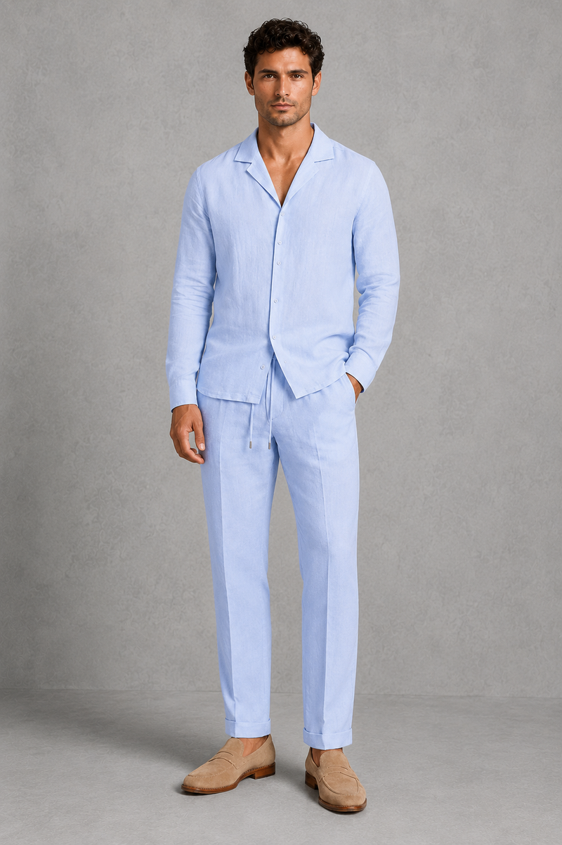 Man wearing a light blue linen suit with beige shoes on a gray background