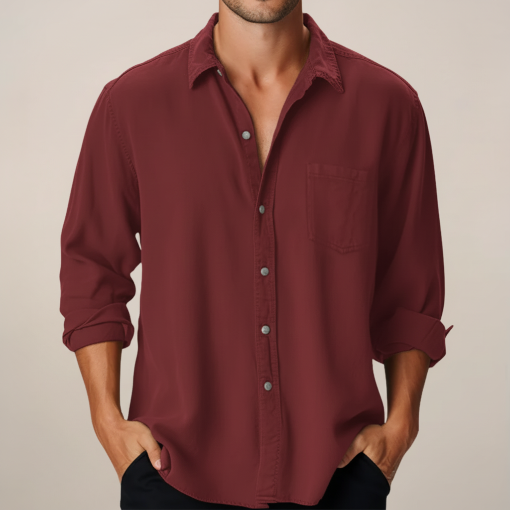 Man wearing a burgundy button-up shirt against a beige background