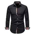 Black shirt with floral patterns on collar and cuffs against a white background