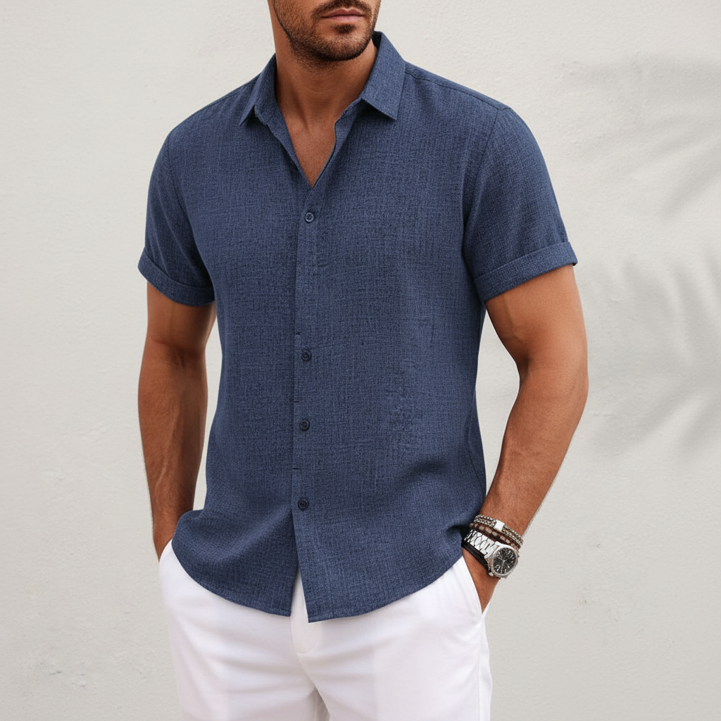 Man wearing a blue short-sleeve shirt with a neutral background