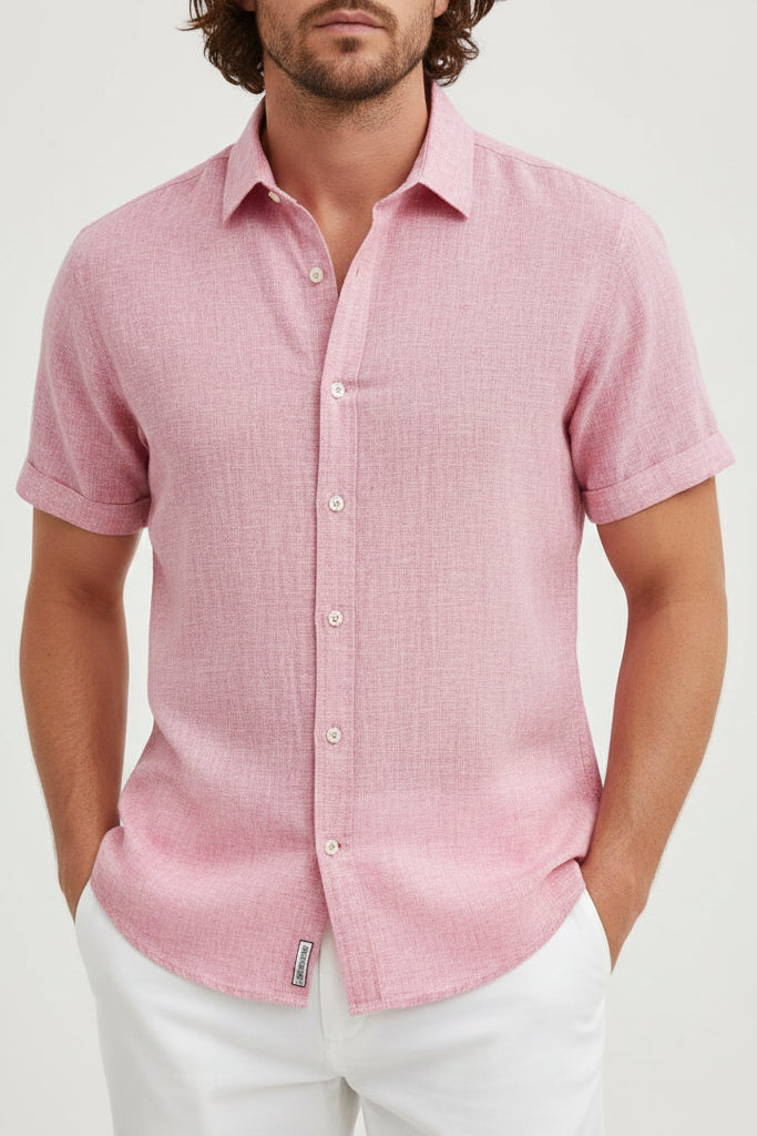 Man wearing a pink short-sleeve shirt against a light gray background