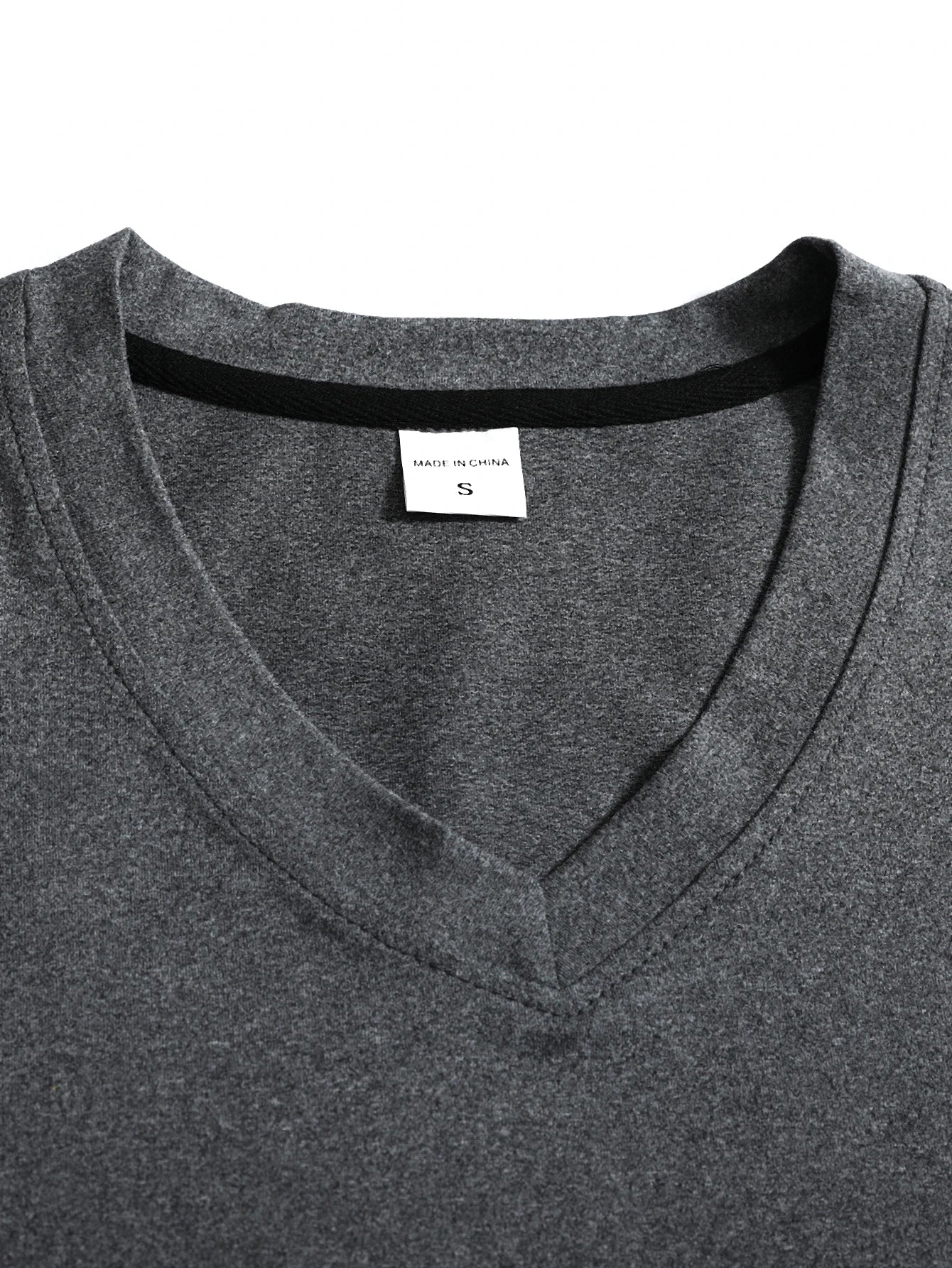 Close-up of a gray shirt with a brand label on a white background