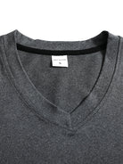 Close-up of a gray shirt with a brand label on a white background