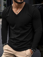 Man wearing a black long-sleeve shirt and beige pants with a blurred background