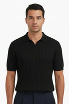 Person wearing a black short-sleeve shirt and dark pants on a white background
