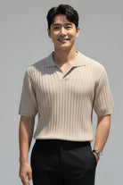 Person wearing a light-colored pleated shirt holding a camera on a white background