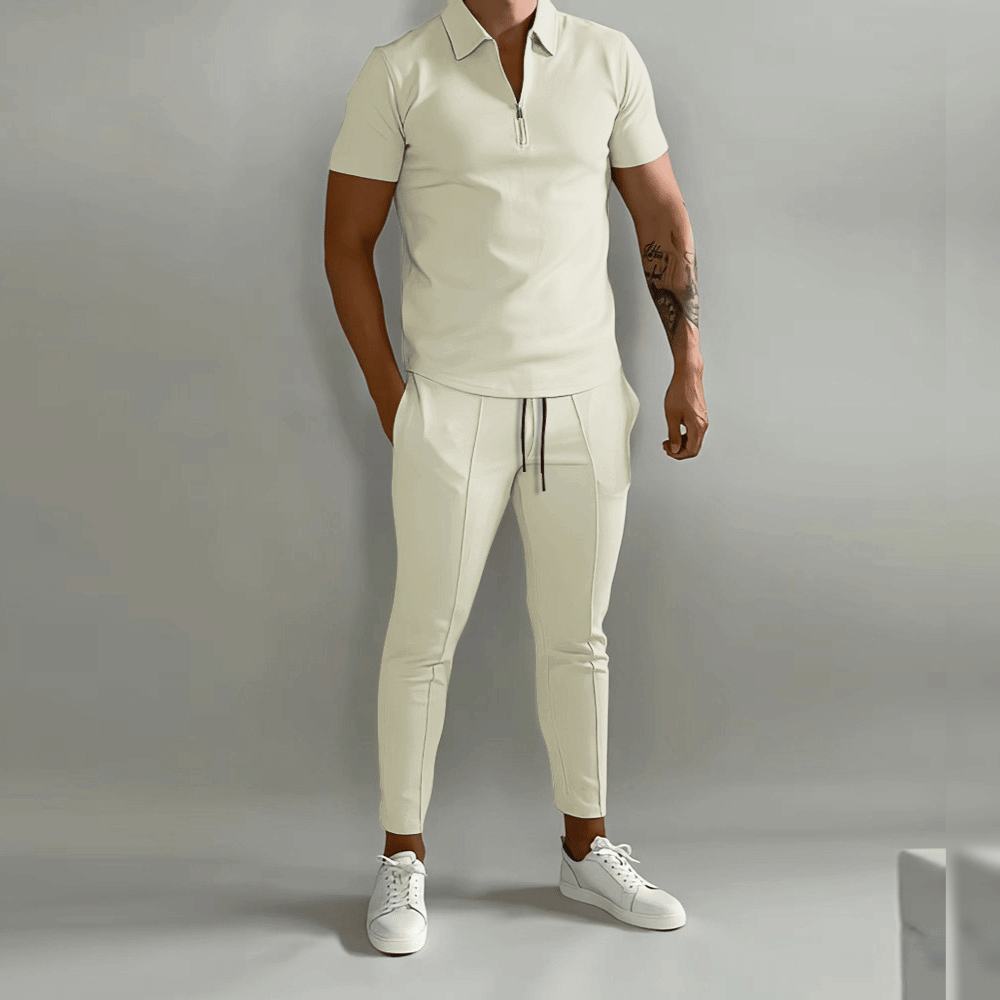 Person wearing a beige outfit with white sneakers on a gray background