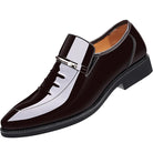 Black patent leather dress shoe with a silver buckle on a white background