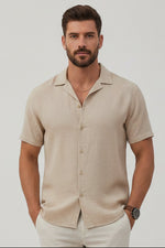 Man wearing a beige short-sleeve shirt on a light gray background