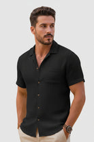 Man wearing a black short-sleeve shirt on a light gray background