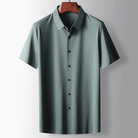 Green short-sleeve shirt on a hanger against a gray background