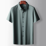 Green short-sleeve shirt on a hanger against a gray background