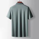 Green polo shirt on a hanger against a gray background