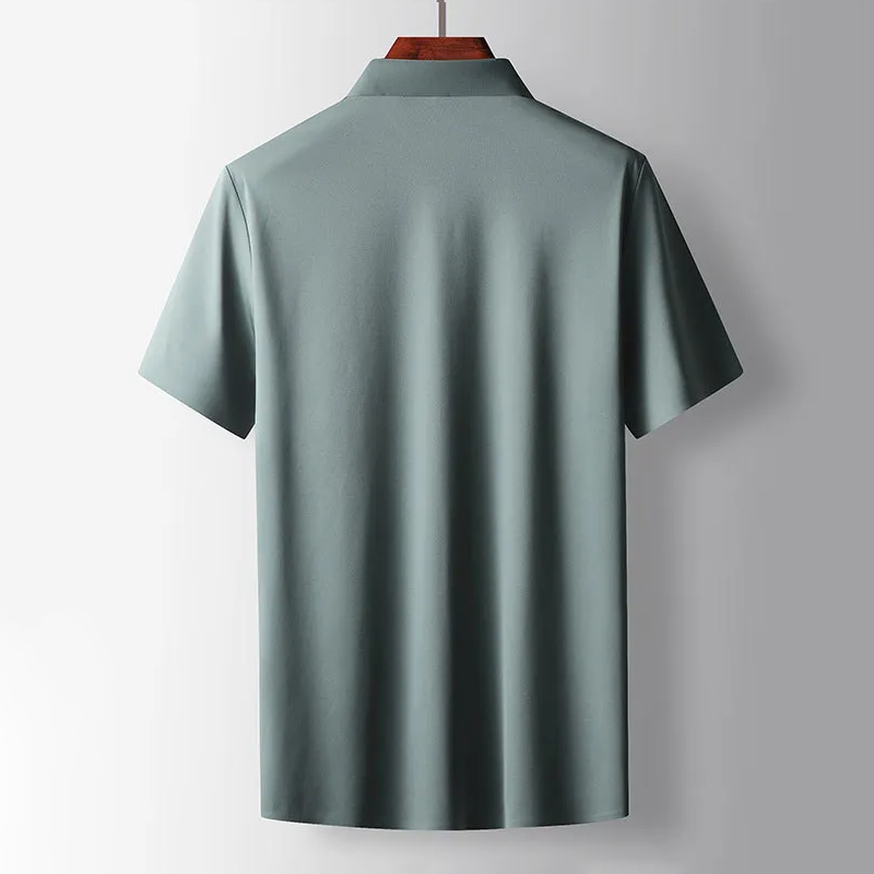 Green polo shirt on a hanger against a gray background