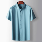 Light blue short-sleeve shirt on a hanger against a gray background
