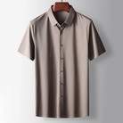 Beige short-sleeve shirt on a hanger against a light gray background