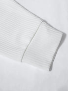 Close-up of a light gray ribbed sweater sleeve on a white background