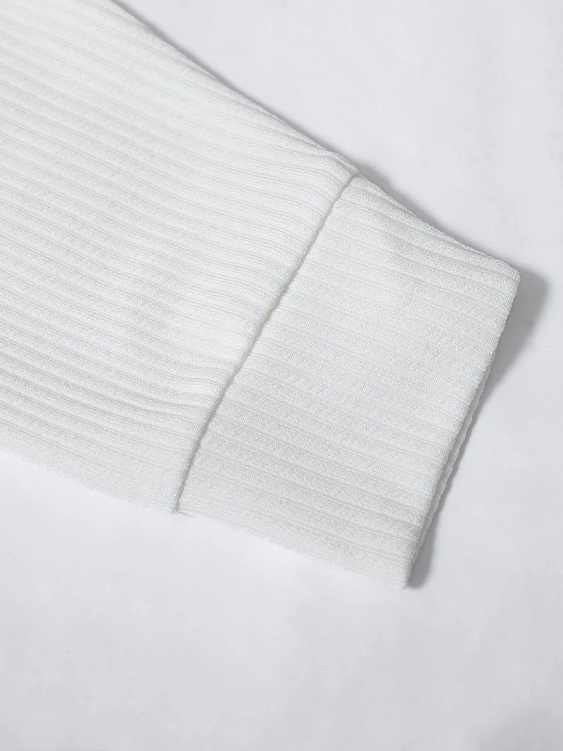 Close-up of a light gray ribbed sweater sleeve on a white background