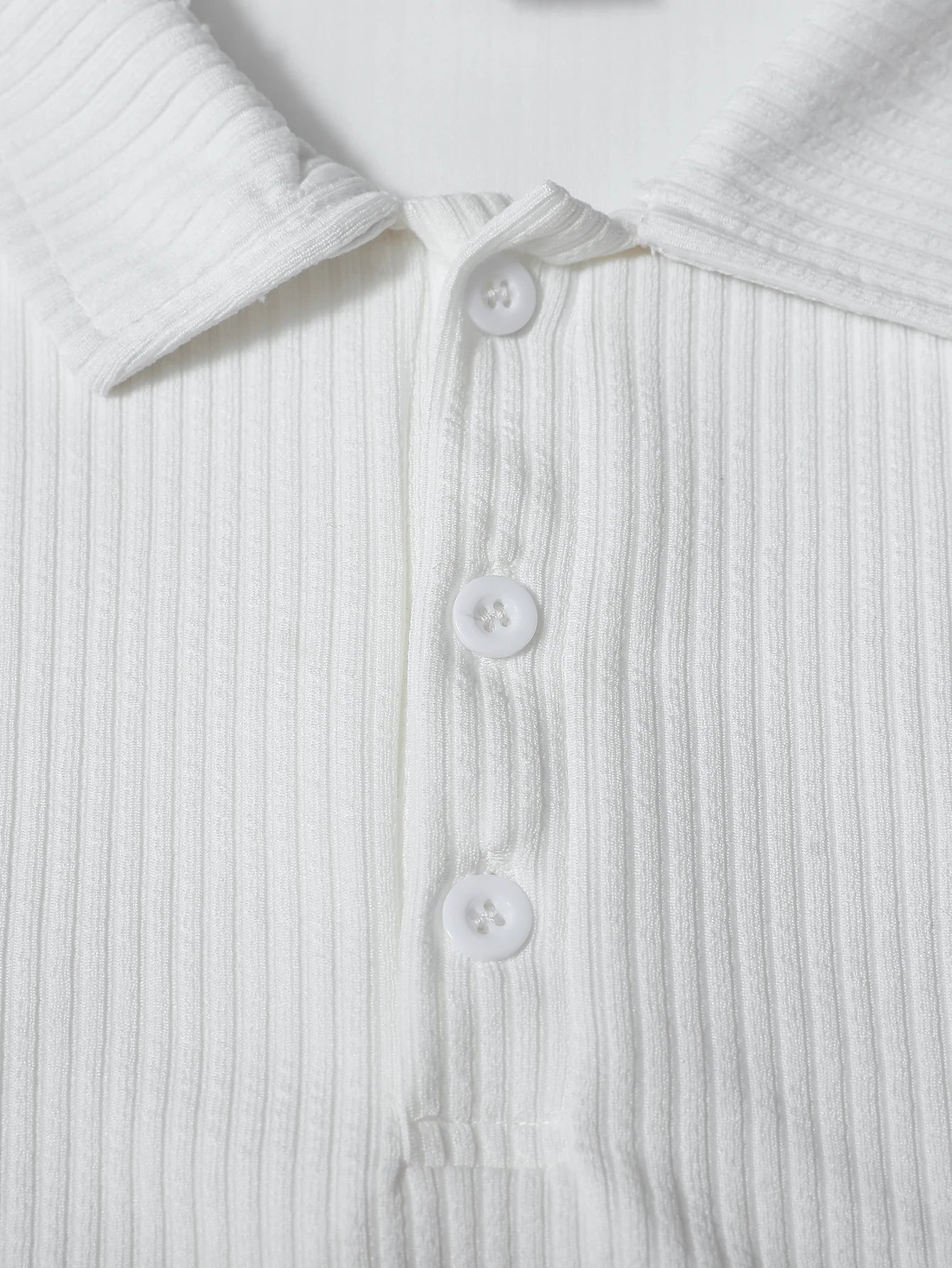 Close-up of a white ribbed shirt with buttons