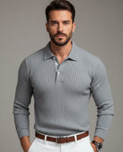 Man wearing a gray ribbed sweater with a blurred background