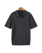 Black ribbed polo shirt on a hanger against a white background