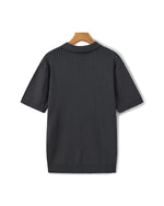 Black ribbed sweater on a wooden hanger against a white background
