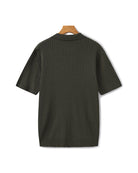 Dark green ribbed sweater on a hanger against a white background