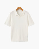 White ribbed polo shirt on a wooden hanger against a white background