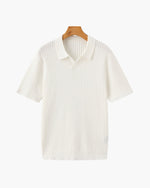 White ribbed polo shirt on a wooden hanger against a white background