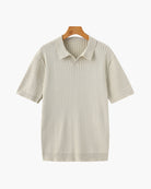 Beige ribbed knit polo shirt on a hanger against a white background